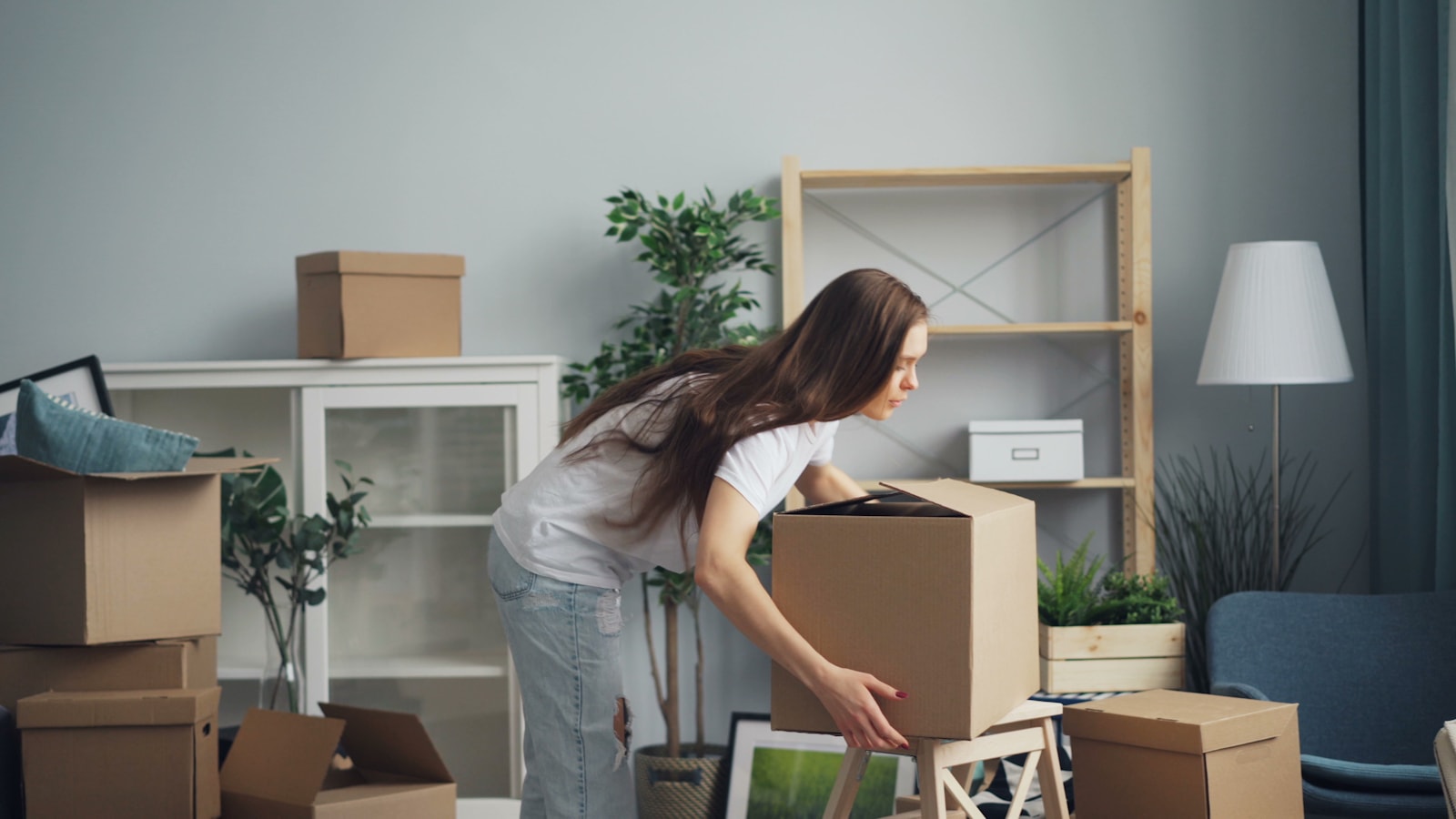 A customer unpacking boxes in a bright new living room after a Sweet Lemon move